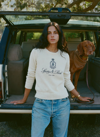 Introducing the Vendome Knitted Sweater in Ecru/Navy—a cream knit sweater with a cropped silhouette, detailed with “Spedy & Rich New York” and a black crest printed on the front. Crafted from 100% cotton for exceptional comfort, this piece is elevated by an embroidered logo for a refined finish.