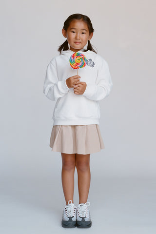 Young girl holding a colorful lollipop against a plain background
