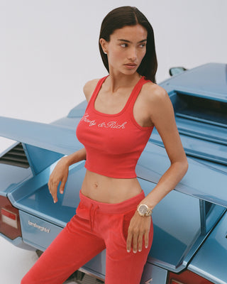 Woman in red outfit standing in front of a blue Lamborghini
