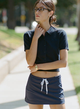Jannie Signature Logo Cashmere SS Cardigan in Dark Navy—this cropped, short-sleeve knit features a button front, classic collar, and subtle signature embroidery on the left chest for a modern touch.