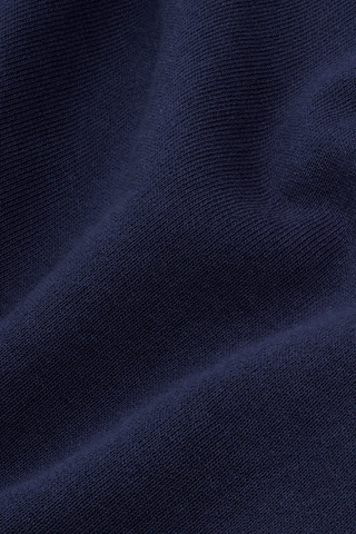 Cadillac x Sporty & Rich Atlas Tee in navy blue, crafted from USA-grown cotton, features a small white circular logo on the left chest and is shown on a white background.