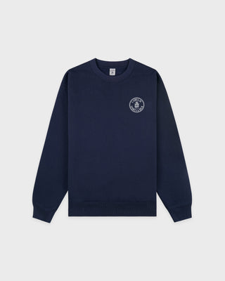 Cadillac x Sporty & Rich Payton Sweatshirt in navy blue, featuring a small white circular logo on the left chest, displayed on a white background.