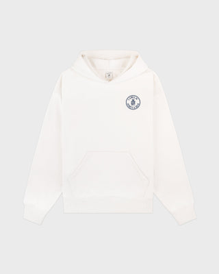 Ecru white Cadillac x Sporty & Rich Tamia Hoodie with a front pocket and a small blue circular logo on the upper left chest, laid flat on a white background. Crafted from premium USA-grown cotton for exceptional comfort and style.
