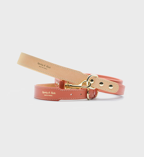 Coral leather dog leash with gold hardware, displayed on a white background. Product: Leather Dog Leash - Coral/Gold.