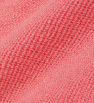 Close-up of textured pink fabric with a diagonal seam, highlighting our Drink More Water Cropped T-Shirt in Strawberry/White, crafted in the USA from 100% USA cotton.