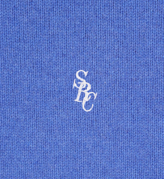 Close-up of the SRC Wool Crewneck in Medium Blue/White, featuring white embroidered overlapping SPC letters. Crafted from soft lambswool with refined Italian craftsmanship. Made in Italy.