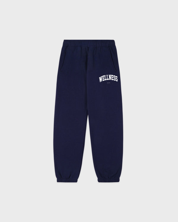 The Wellness Ivy Kids Sweatpant in navy and white features "WELLNESS" printed in white on the left thigh, an elastic waistband and cuffs for comfort, and an oversized fit—making it a perfect choice for stylish kids’ clothing.