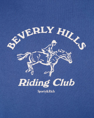 Blue t-shirt with white 'Beverly Hills Riding Club' text and horse graphic, featuring Sporty&Rich branding.