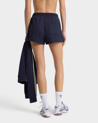 Person wearing navy shorts and white socks with a white background