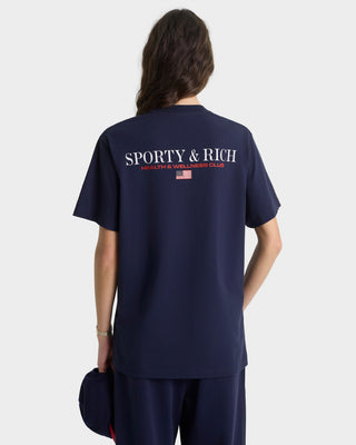 Person wearing a navy blue 'Sporty & Rich' t-shirt on a white background