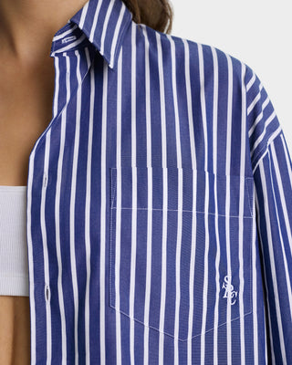 Blue and white striped shirt with a brand logo on a plain background