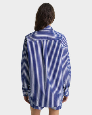 Person wearing a blue and white striped shirt on a plain background