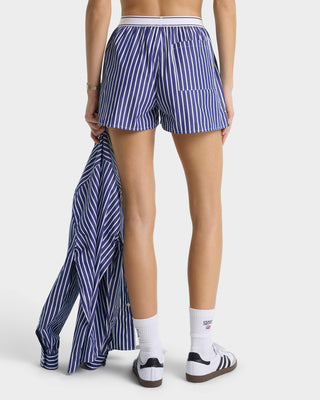 Person wearing blue and white striped shorts on a plain background
