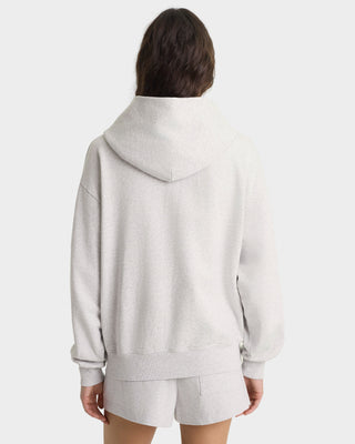 Person wearing a gray hoodie and shorts set on a white background