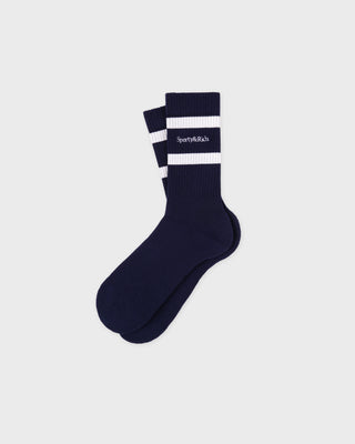 Navy blue sock with white stripes on a light gray background