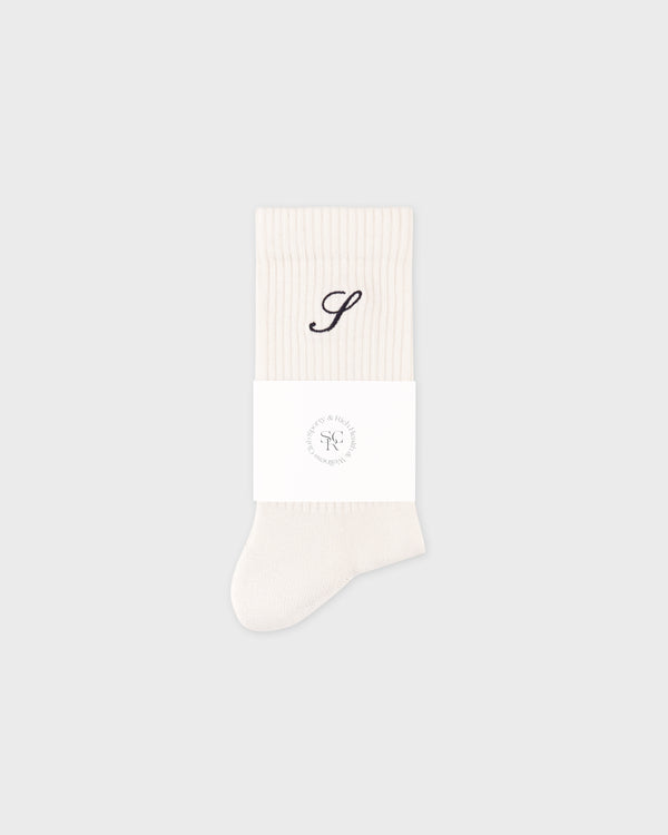 White sock with a black monogram on a light gray background
