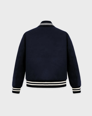 Navy blue varsity jacket with white stripes on a light gray background