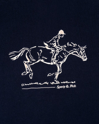 Embroidered design of a horse and rider on a black background with 'Sporty & Rich' branding.