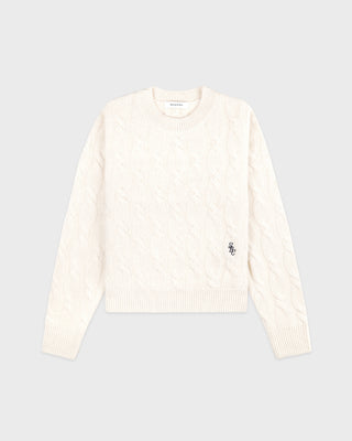 White sweater with a small logo on a light gray background