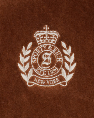 Embroidered logo on a brown fabric background