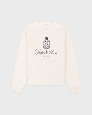 Introducing the Vendome Knitted Sweater in Ecru/Navy—a cream knit sweater with a cropped silhouette, detailed with “Spedy & Rich New York” and a black crest printed on the front. Crafted from 100% cotton for exceptional comfort, this piece is elevated by an embroidered logo for a refined finish.