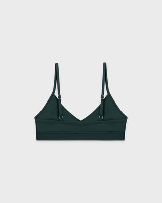 Green bralette with thin straps on a light gray background