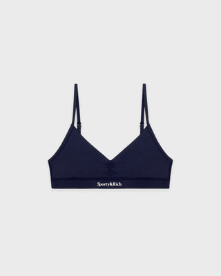 Navy blue bralette with thin straps on a light gray background