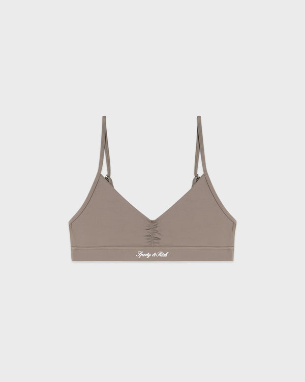 Signature Logo Mini Sports Bra in Hazelnut/White with thin straps and a Simply A Real logo printed on the front band, crafted from a soft nylon-spandex blend and featuring adjustable back straps, displayed on a white background.