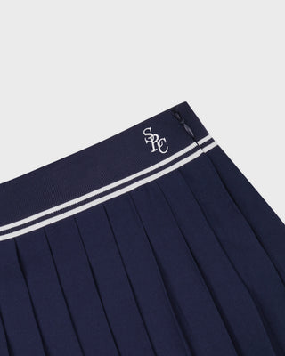 Navy pleated skirt with white trim and logo on a light gray background