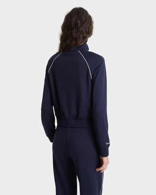Person wearing a navy tracksuit on a white background