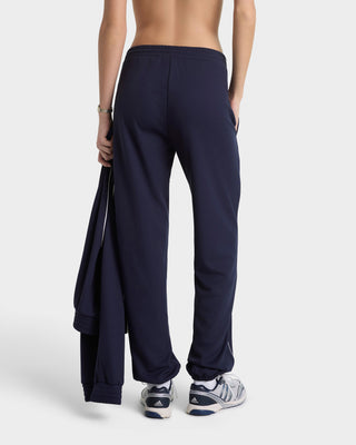 Person wearing navy blue sweatpants on a white background