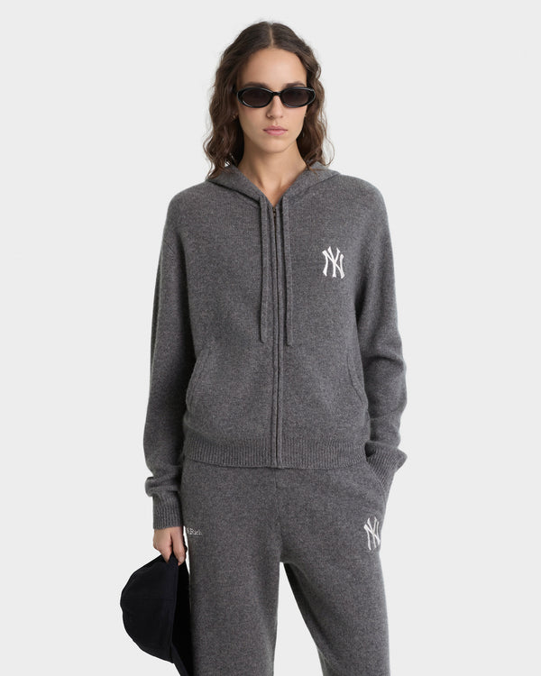 Person wearing a gray hoodie with a logo on a white background