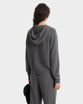 Person wearing a gray hoodie and pants on a white background