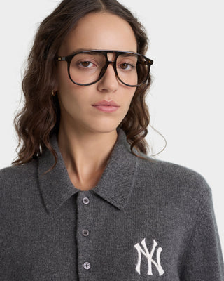 Person wearing a gray polo shirt with a New York Yankees logo on a white background