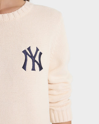 Cream-colored sweater with a navy blue NY Yankees logo on a white background