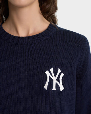 Navy blue sweater with a white logo on a neutral background