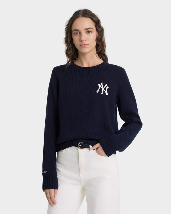 Person wearing a navy blue sweater with a logo on a white background