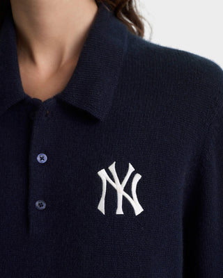Navy blue polo shirt with a white logo on a plain background