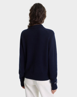Person wearing a navy blue sweater with a white background