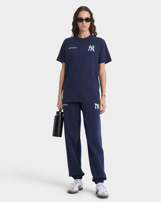 Person wearing navy blue outfit with brand logo on a white background