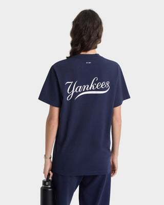 Person wearing a navy blue t-shirt with 'Yankees' printed on the back, holding a black water bottle.