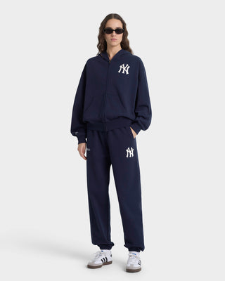 Person wearing a navy tracksuit with a logo on a white background