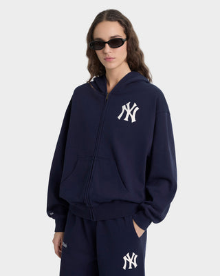 Person wearing a navy blue hoodie with a logo on a white background