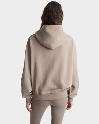 Person wearing a beige hoodie and pants on a white background