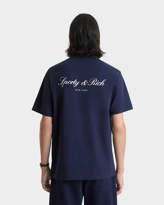 Person wearing a navy blue t-shirt with 'Sporty & Rich' logo on the back, standing against a white background.