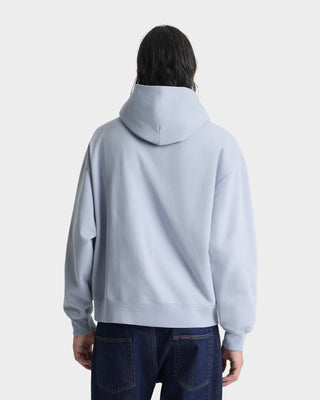 Person wearing a light blue hoodie from behind on a white background
