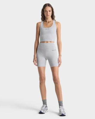Woman wearing a gray athletic outfit on a white background