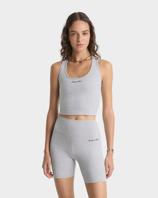 Woman wearing a gray athletic outfit with a plain background