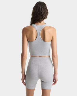 Woman wearing a gray athletic outfit on a white background