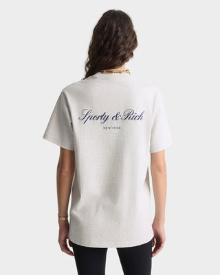 Person wearing a white t-shirt with 'Sporty & Rich' branding on the back, standing against a plain background.